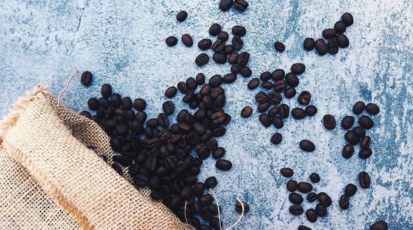 Coffee beans in burlap bag with blue background