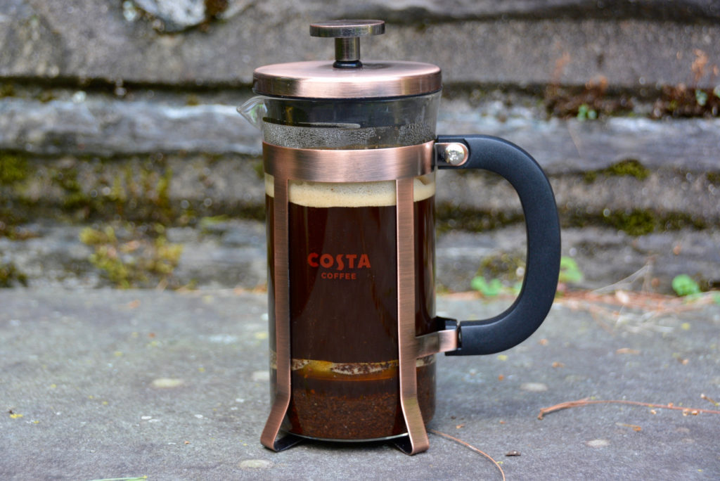 French press from costa coffee with coffee insider on a cement background