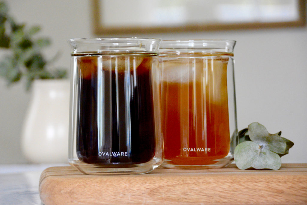 Ovalware clear tasting cups, one filled with cold brew and one filled with iced chai tea