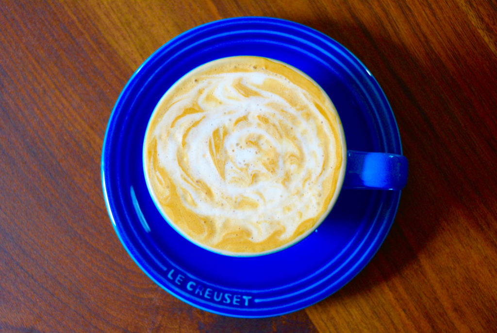 cappuccino in a blue cup with latte art design