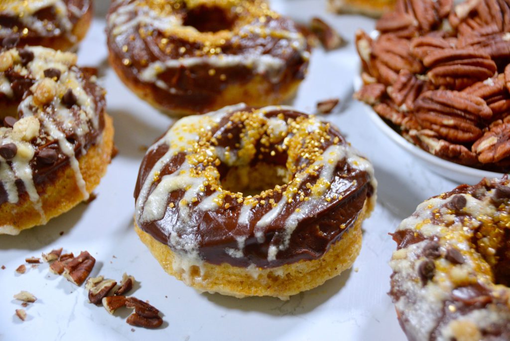chocolate frosted donuts with gold and white and pecans