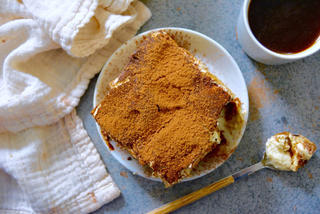 tiramisu on a place with coffee cups in background