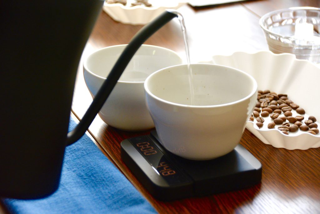 water pouring into tasting cup from black kettle