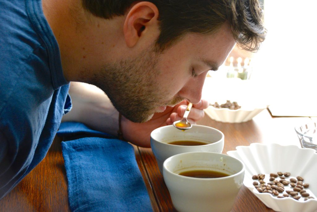 man slurps coffee at a coffee tasting and coffee cupping