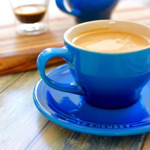 blue mug with coffee with espresso and blue mug behind it