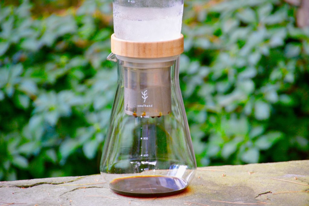 soulhand cold brew coffee maker on pavement with greenery in background