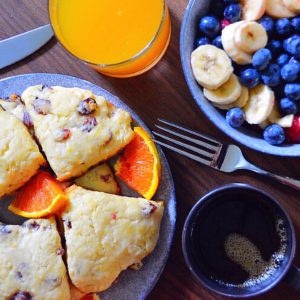 cranberry orange scones on a purple plate with coffee