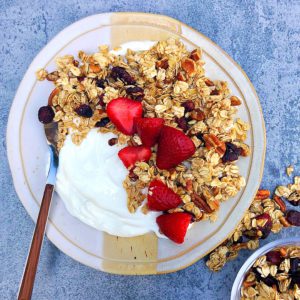 yogurt with granola and strawberries on a plate 