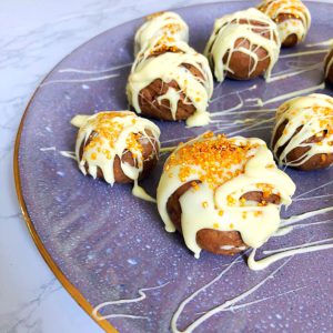 white chocolate covered cake truffles on a purple plate 