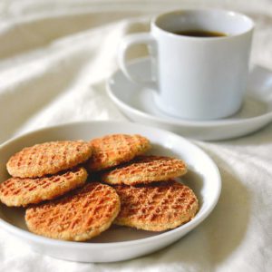 coffee with mini strop-waffles on a white sheet