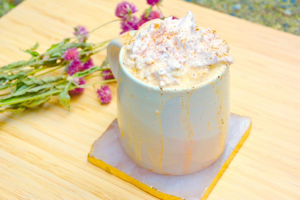 pink mug with strawberry coffee latte and pink dried flowers