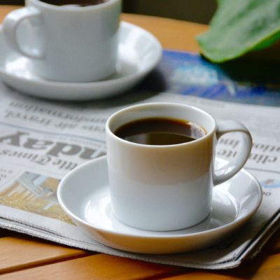 two small cups of coffee on a newspaper