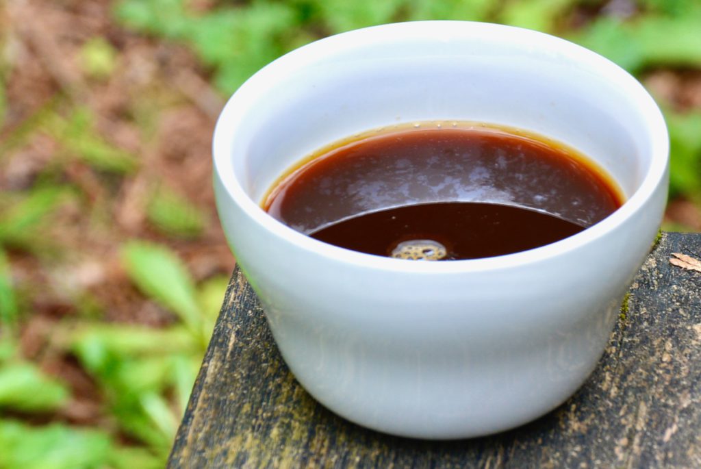 white coffee cup on a bench outdoors