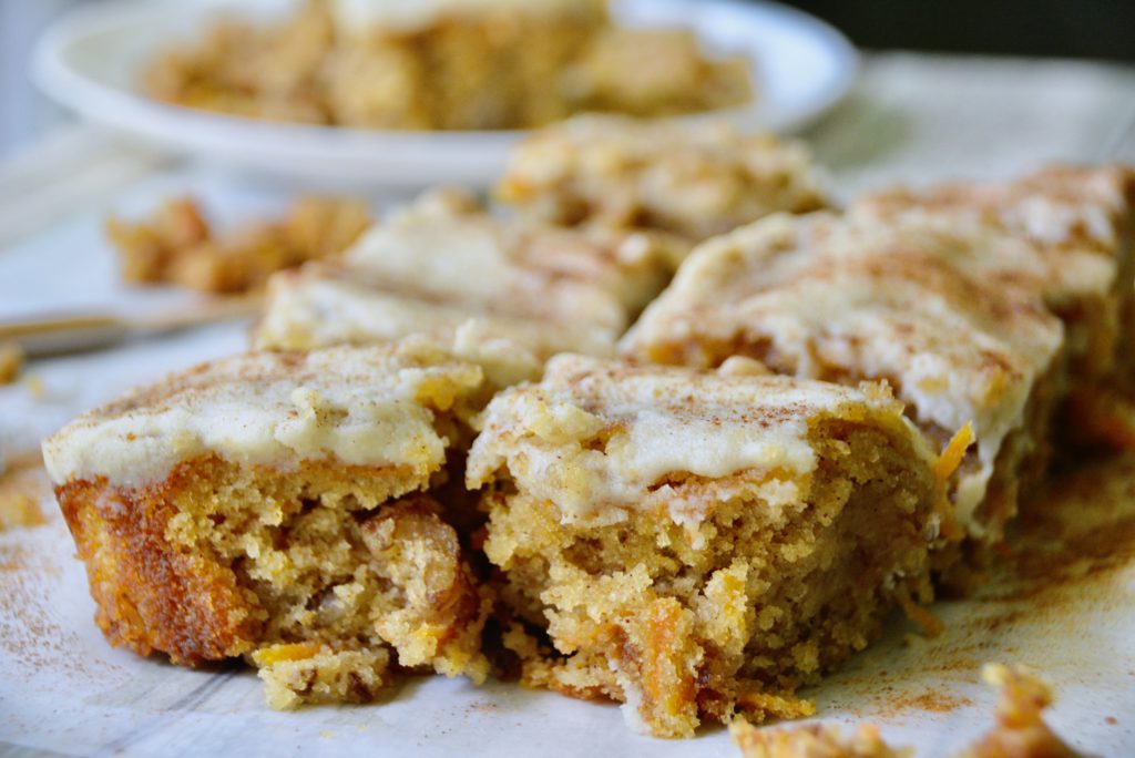 carrot cake bars with icing and dusted cinnamon